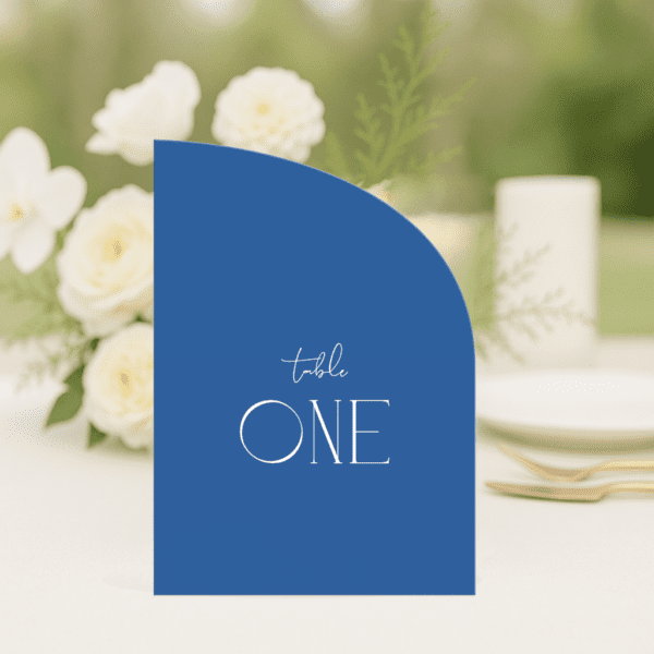 Ellie wedding table number in half arch shape featuring romantic, modern fonts and soft colour palette, styled for an elegant reception table.