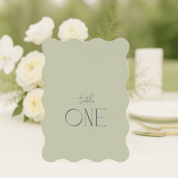 Ellie wedding table number in wave shape featuring romantic, modern fonts and soft colour palette, styled for an elegant reception table.