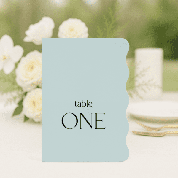 Evermore wedding table number in long wave shape featuring romantic, modern fonts and soft colour palette, styled for an elegant reception table.