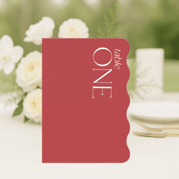 Sam wedding table number in long edge wave shape featuring romantic, modern fonts and soft colour palette, styled for an elegant reception table.